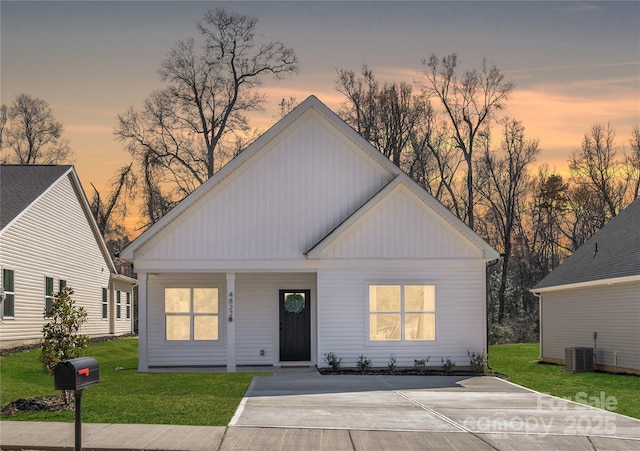 view of front of property with covered porch, central AC unit, board and batten siding, and a front lawn