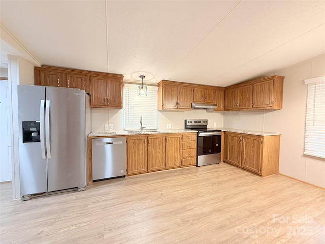 kitchen featuring light countertops, appliances with stainless steel finishes, a sink, light wood-type flooring, and under cabinet range hood