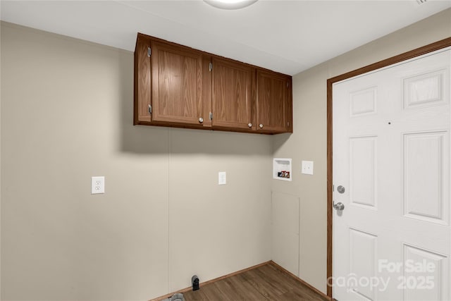 washroom featuring dark wood finished floors, cabinet space, and hookup for a washing machine