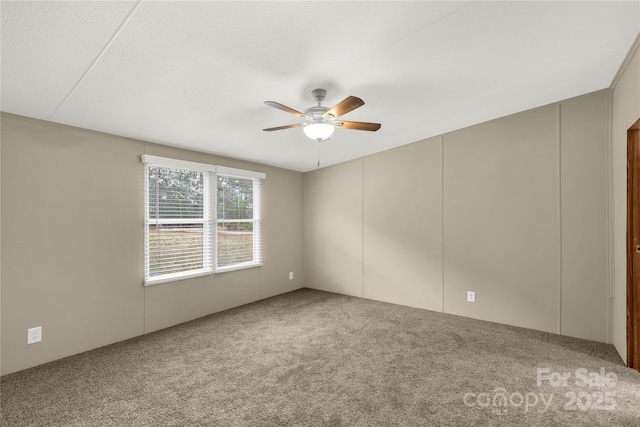 empty room featuring a ceiling fan and carpet floors