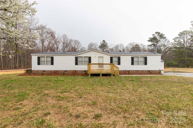 manufactured / mobile home featuring a front lawn, crawl space, a wooden deck, and roof with shingles