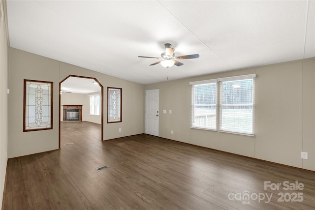 interior space featuring a wealth of natural light, dark wood-type flooring, ceiling fan, and visible vents