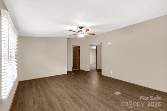 empty room with a ceiling fan, visible vents, and wood finished floors