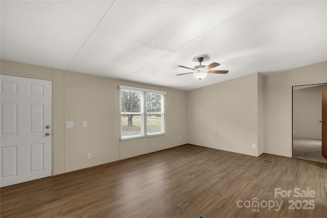 unfurnished room featuring a textured ceiling, wood finished floors, and a ceiling fan