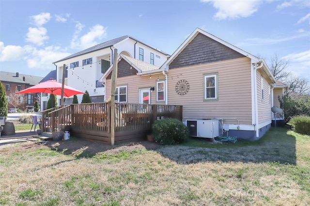 rear view of property with a yard and a wooden deck