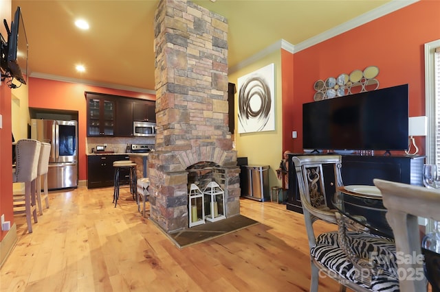 interior space featuring ornate columns, crown molding, and light wood finished floors