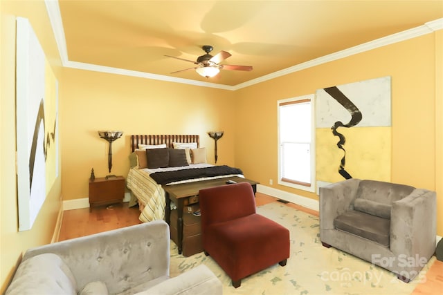 bedroom featuring ornamental molding, wood finished floors, a ceiling fan, and baseboards