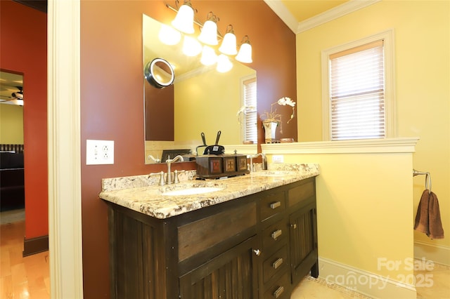 full bath with ornamental molding, a ceiling fan, a sink, and double vanity