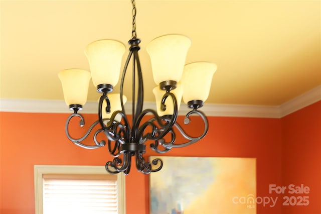 room details with ornamental molding and an inviting chandelier