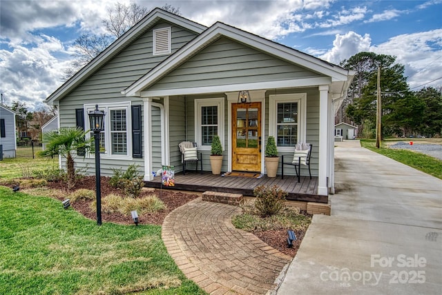 bungalow-style home with covered porch and a front lawn