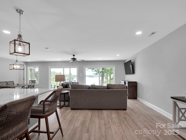 living area featuring recessed lighting, light wood-type flooring, visible vents, and baseboards