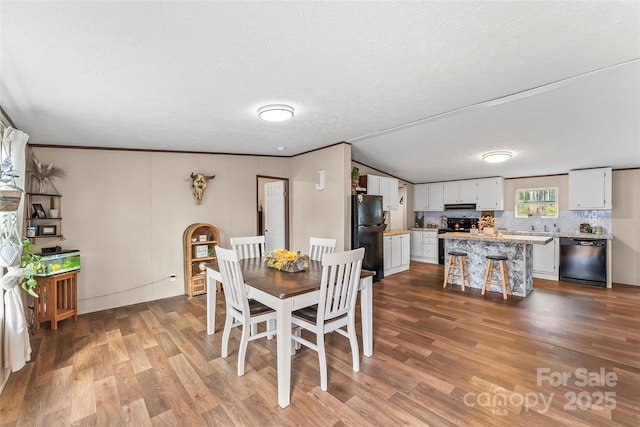 dining room featuring ornamental molding, a textured ceiling, and wood finished floors