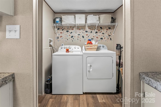 laundry area with laundry area, washing machine and clothes dryer, and wood finished floors