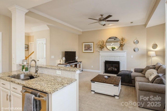 living room featuring light carpet, ceiling fan, ornamental molding, and a tiled fireplace