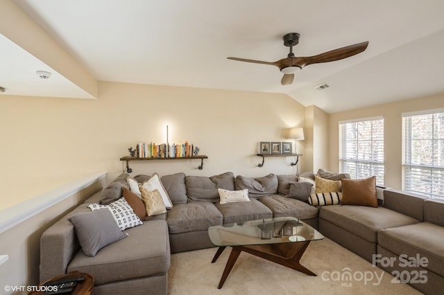 carpeted living area featuring ceiling fan, visible vents, and vaulted ceiling