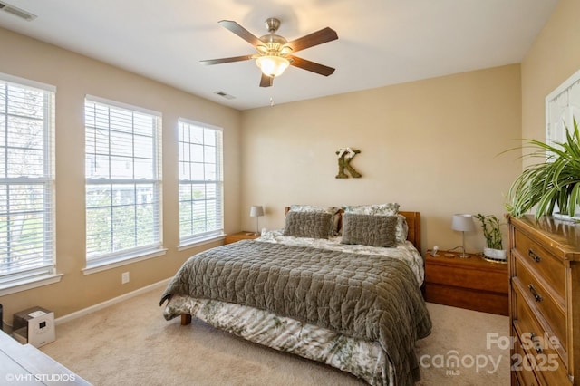 carpeted bedroom with baseboards, visible vents, and a ceiling fan