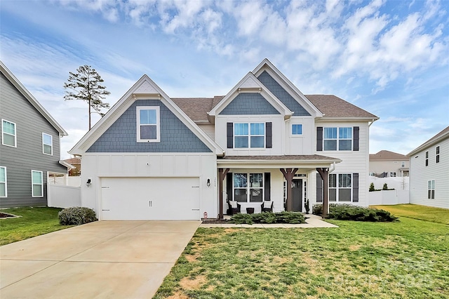 view of front of house featuring covered porch, fence, driveway, a front lawn, and board and batten siding