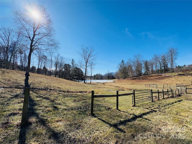 view of yard with a rural view and fence