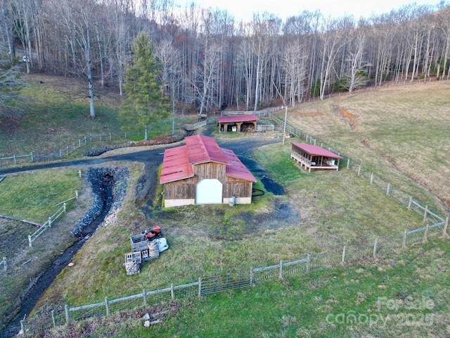 aerial view featuring a wooded view and a rural view