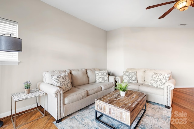 living area featuring a ceiling fan, wood finished floors, visible vents, and baseboards