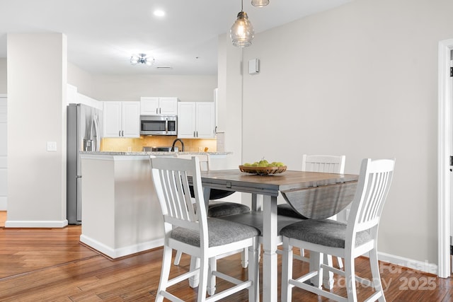 dining room featuring light wood-style flooring and baseboards