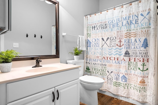 full bathroom featuring a shower with shower curtain, vanity, toilet, and wood finished floors