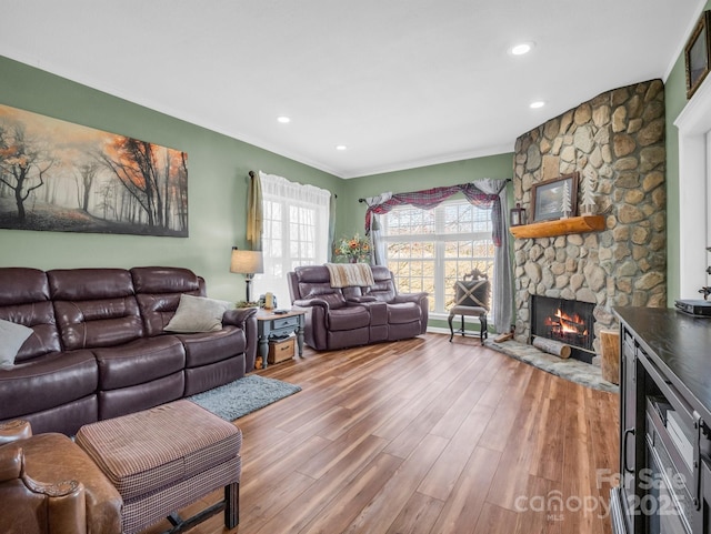 living area featuring recessed lighting, wood finished floors, a fireplace, and crown molding