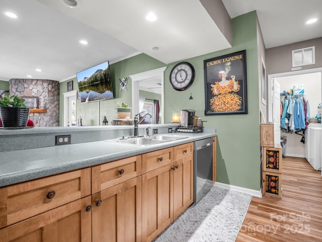 kitchen with stainless steel dishwasher, recessed lighting, light wood-type flooring, and a sink