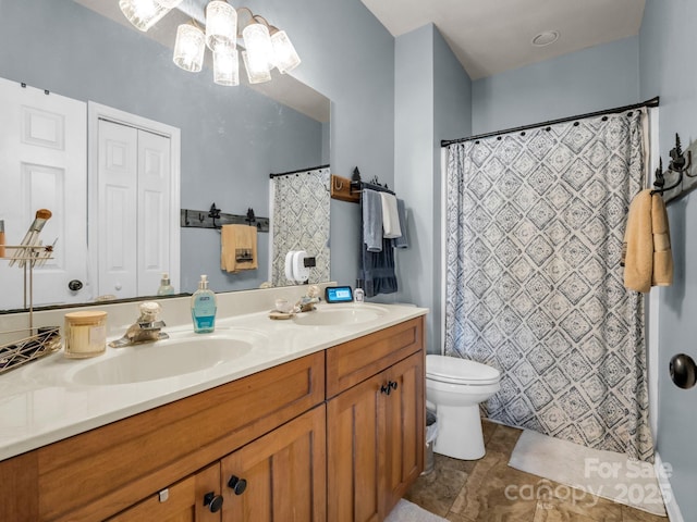 bathroom featuring double vanity, curtained shower, toilet, and a sink