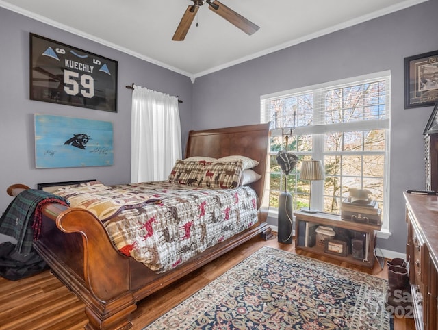 bedroom with baseboards, wood finished floors, ceiling fan, and ornamental molding