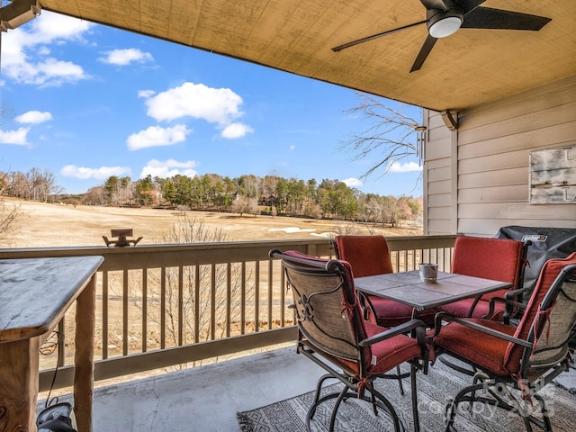 wooden terrace featuring outdoor dining area and a ceiling fan