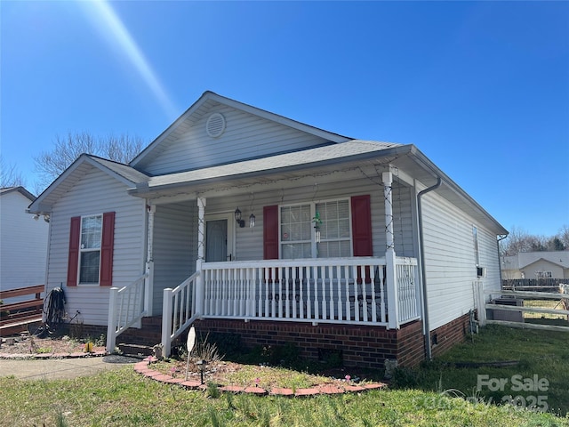 view of front facade featuring fence and covered porch