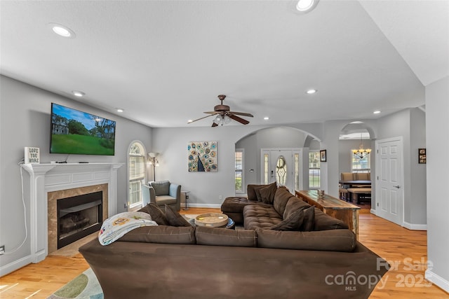 living area featuring arched walkways, plenty of natural light, recessed lighting, and light wood-type flooring