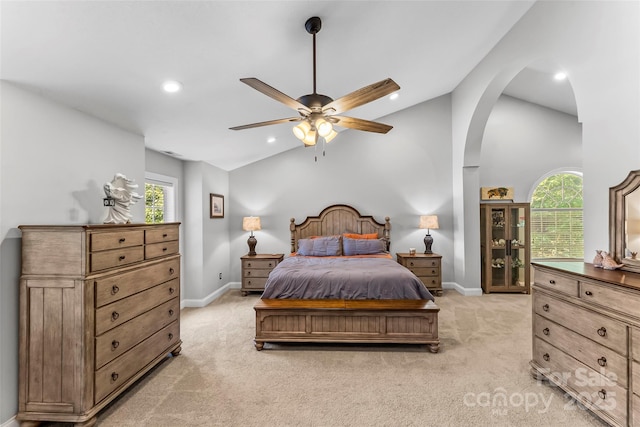 bedroom with light carpet, lofted ceiling, recessed lighting, arched walkways, and baseboards