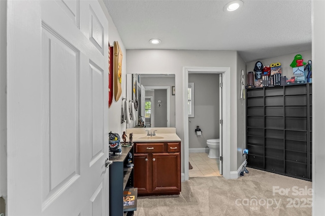 bathroom with toilet, recessed lighting, tile patterned flooring, baseboards, and vanity