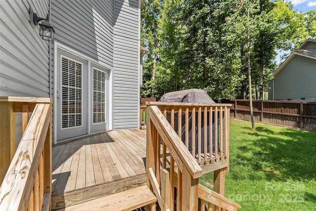 wooden deck featuring a yard and fence