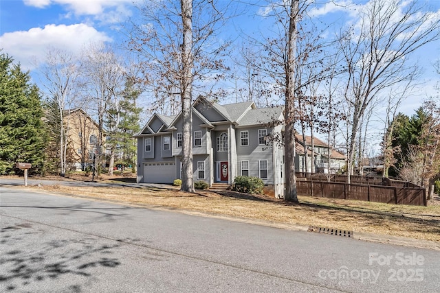 view of front of property with fence, a garage, and driveway