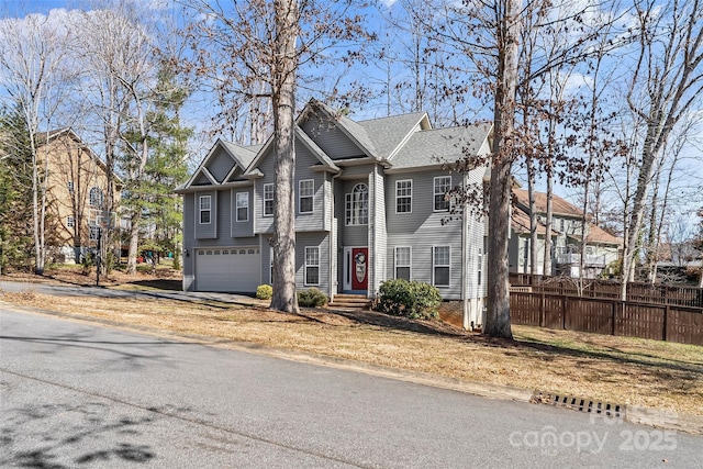 view of front of home featuring fence and a garage