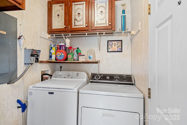 washroom featuring washer and dryer, cabinet space, and electric panel