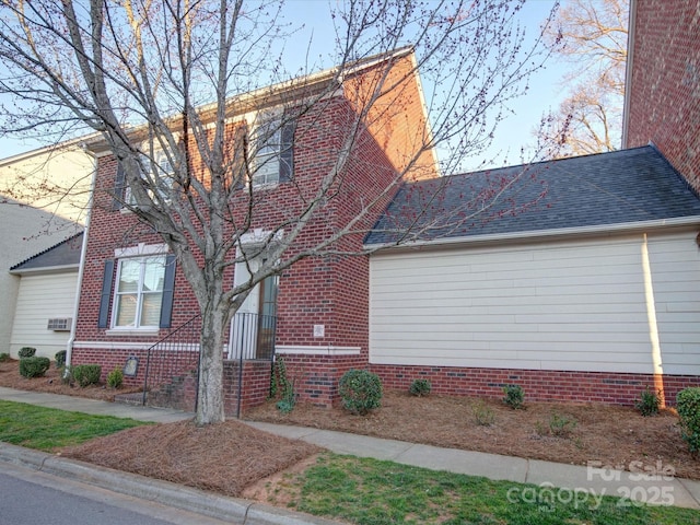 view of property exterior with a shingled roof