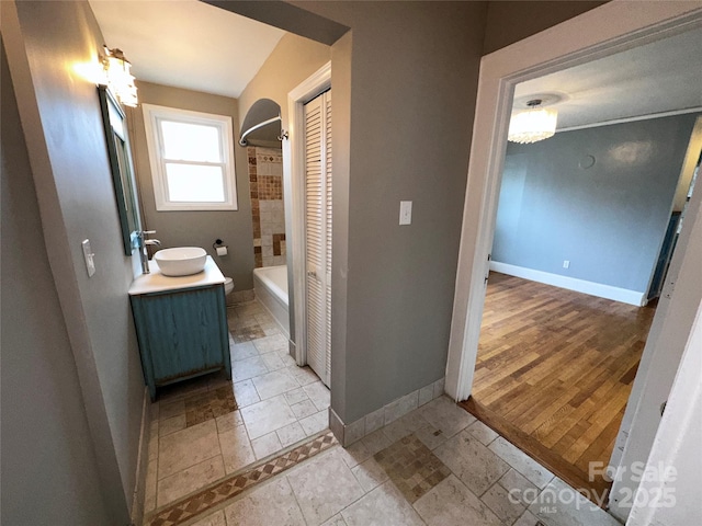 full bath with vanity, baseboards, and bathing tub / shower combination