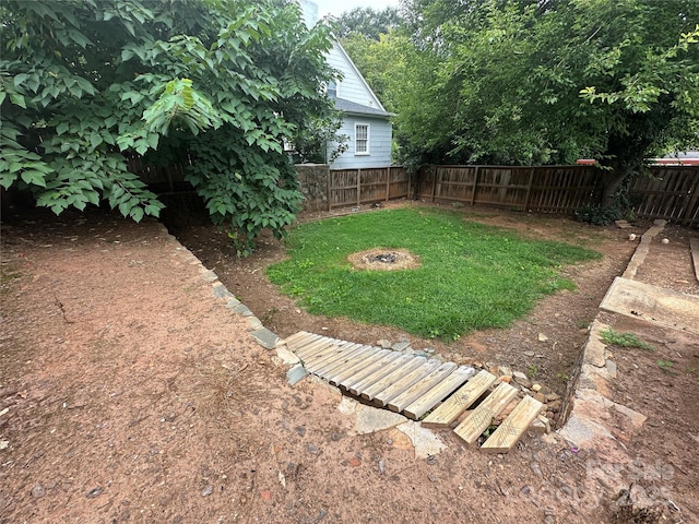 view of yard featuring an outdoor fire pit and a fenced backyard