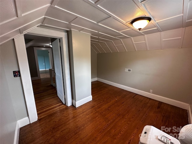 additional living space featuring baseboards, vaulted ceiling, and wood finished floors