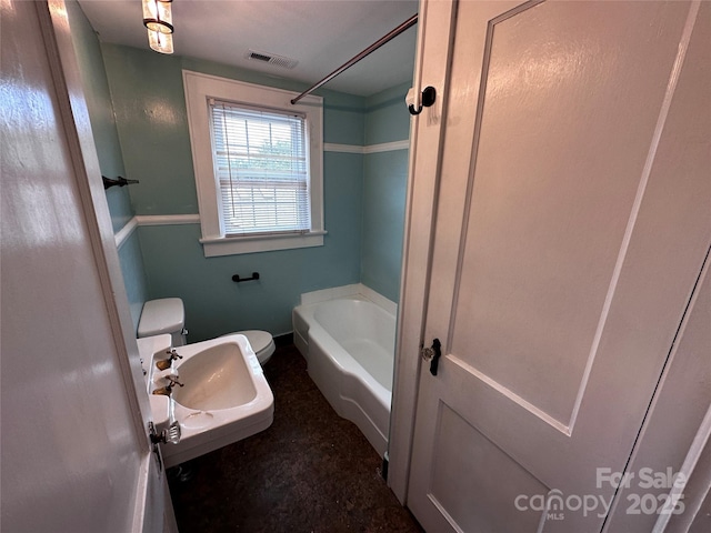 bathroom featuring toilet, a sink, visible vents, and a bath