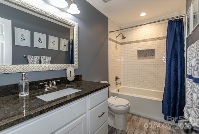 full bathroom featuring toilet, ornamental molding, wood finished floors, shower / tub combo, and vanity