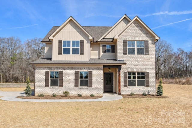 craftsman inspired home with board and batten siding, brick siding, and a shingled roof