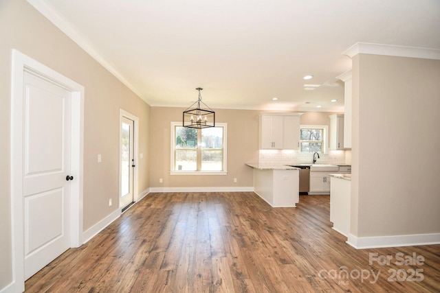 kitchen with light countertops, decorative backsplash, white cabinets, wood finished floors, and baseboards