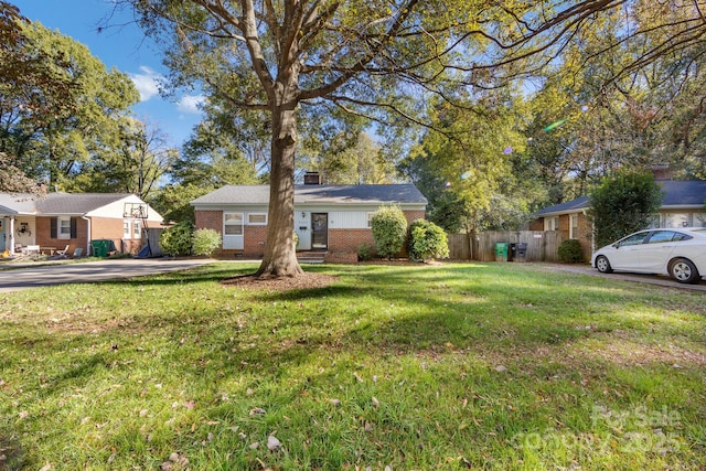 ranch-style home featuring a front yard, brick siding, fence, and a chimney