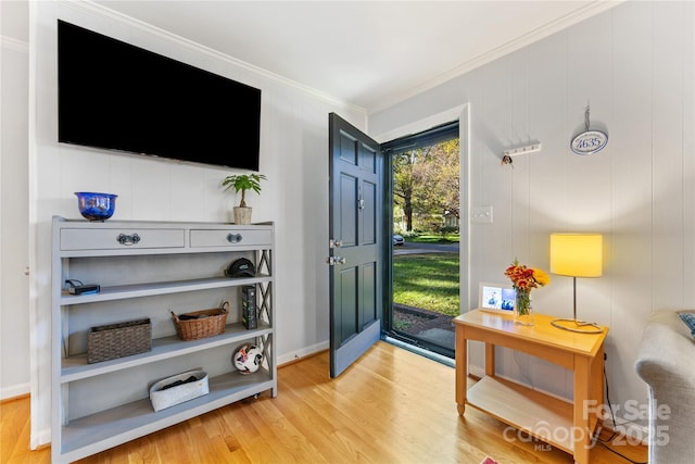 entrance foyer featuring crown molding and wood finished floors