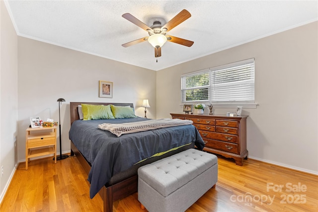 bedroom with light wood finished floors, baseboards, and crown molding